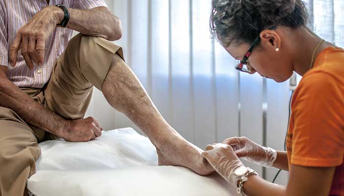 A podiatrist inspecting a patients foot