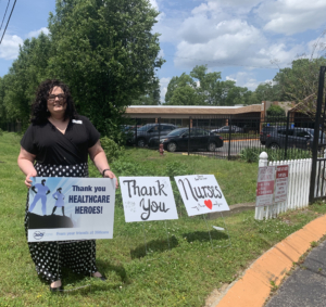 Shannon McCullough Area Manager - Tennessee is holding a COVID-19 sign from 360care.